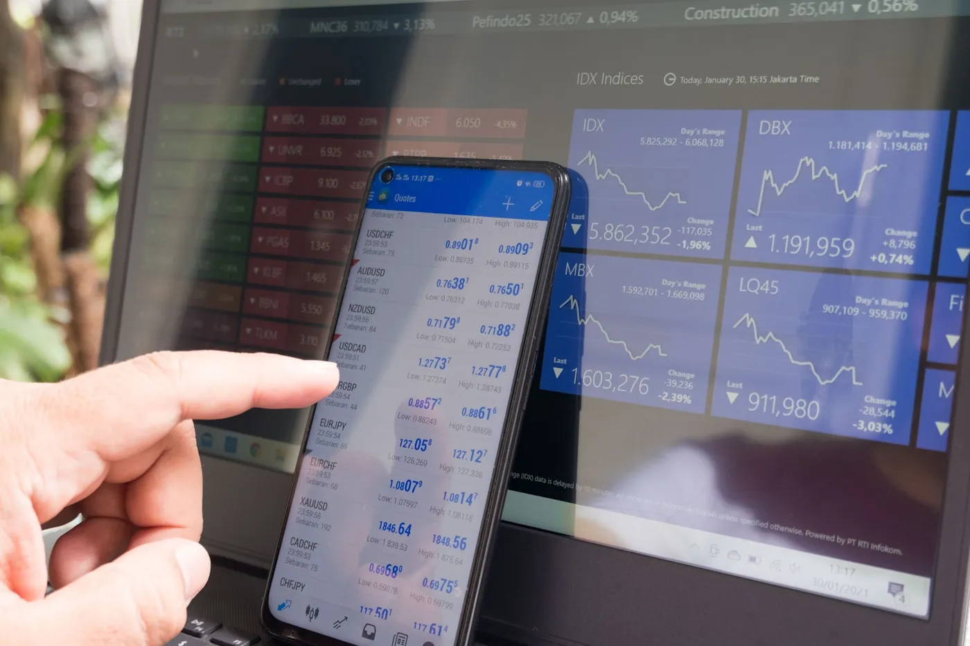 Person holding a phone displaying cryptocurrency prices, stock photo